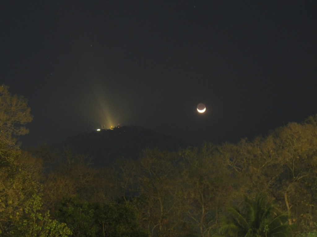 Moonset next to the temple Wat Phra That Doi Suthep, taken in the park of Chiang Mai University, Thailand