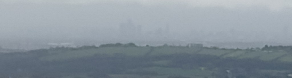 View of Manchester from Snake Road with lots of digital zoom. You can just make out the outlines of the skyscrapers.